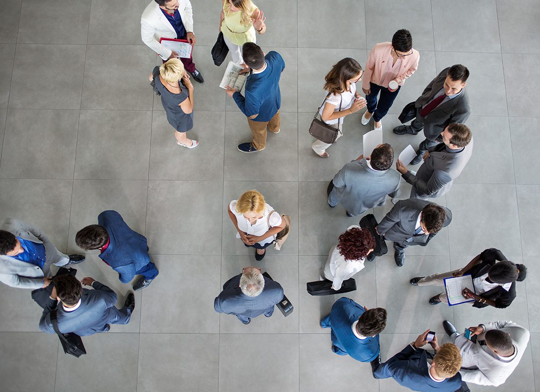 Insurance Solutions - Overhead View of Business People Walking and Talking in Groups at an Office